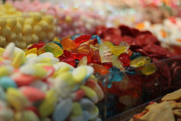 A variety of sweet candy jelly beans in different colors. Market stall full of candys. Assorted colorful candies at a market stall.  Rubber candies in all kinds of colors and flavors. Close up