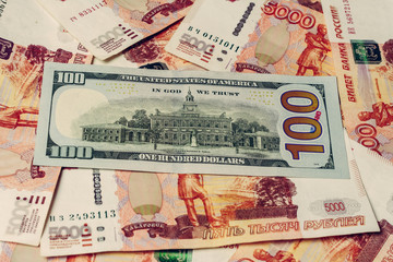 one hundred dollar bill lies on 5000 Russian rubles, the side where the hall of independence is depicted. 2019