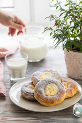 Cheesecake rolls for Breakfast on a wooden table by the window with a cat