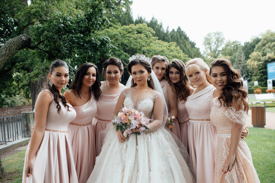 Beautiful bride and her friends- bridesmaids having fun after wedding ceremony. Wedding celebration. Happy girls at their best friend's wedding. Beautiful and elegant bride with bridesmaids