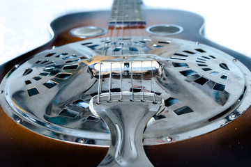 A closeup of a guitar on a white back drop