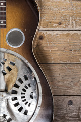 A detail of a vintage guitar on a wooden background