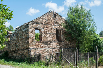 Old destroyed abandoned rural stone house closeup