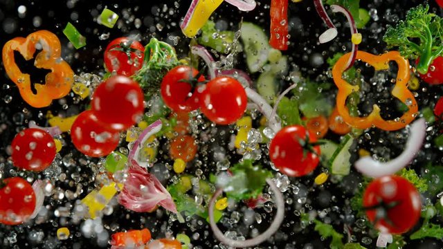 Fresh vegetables with water droplets exploding on black background. Filmed on high speed cinema camera, 1000fps.