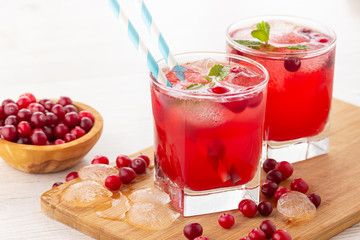 Red coctail with cranberry, vodka and ice. Refreshment drink.