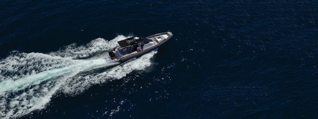 Aerial drone photo of inflatable power boat cruising in high speed the Aegean deep blue sea