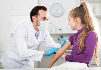 Obraz premium Male doctor injecting little patient