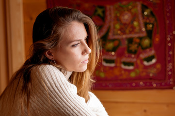 Pretty blonde girl in a wooden cabin