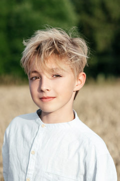 Portrait of blond boy in an oat field