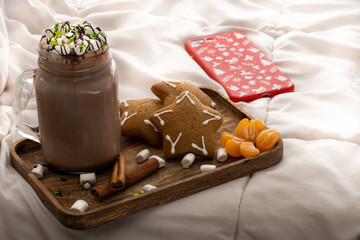 New Year's morning sweet breakfast of hot chocolate with ginger cookies with cinnamon marshmallows and tangerines