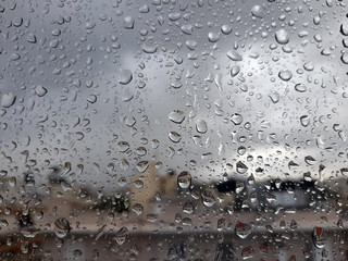 Window glas with rain drops during a winter storm in Crete; rain drops viewed from house interior