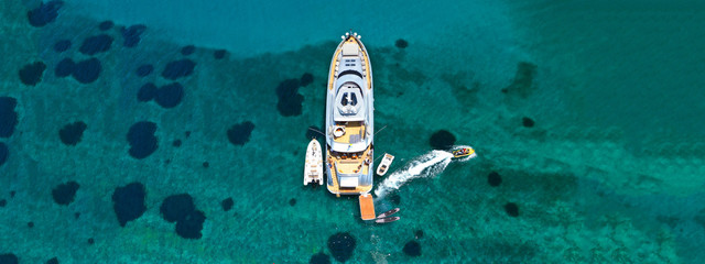 Aerial drone ultra wide photo of luxury yacht docked in tropical exotic island with turquoise sea