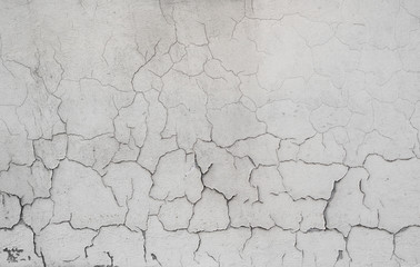 Cracked concrete grey wall covered with gray cement texture as background can be used in design. Dirty concrete texture with cracks and holes.
