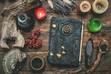 Book of magic and other magical accessories on wooden table background. Witchcraft. Witch doctor.
