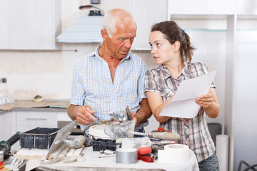Woman and father discussing instructions for mixer tap