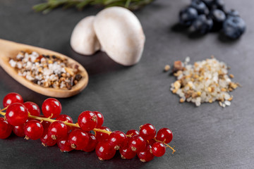 Verschiedene Zutaten und Kräuter wie Rosmarin und Champignons auf einer Schiefertafel