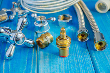 Spare parts and accessories for plumbing repair on blue wooden boards