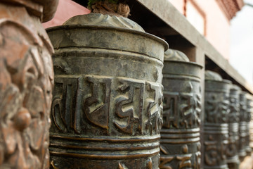 Buddhist prayer spinning drums with ancient mantras close up. Fixture for traditionhal Buddist...