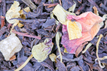black tea with fruit pieces and flower petals macro isolate