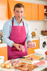 Man cutting raw meat for dinner