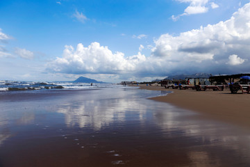 Beautiful sand beach in Oliva Valencia, Spain. Sand dunes and rainy clouds in background. Summer vacation in Spain. Huge sand beach and the sea. Protected landscape area. 