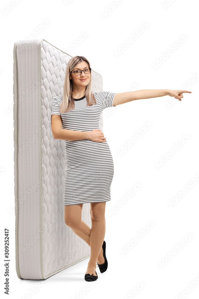 Sticker young blond woman leaning on a bed mattress and pointing to the side