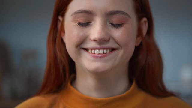 cheerful redhead teenage girl smiling at camera