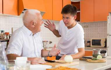 Obraz na płótnie Canvas Teenage boy friendly talking to grandfather