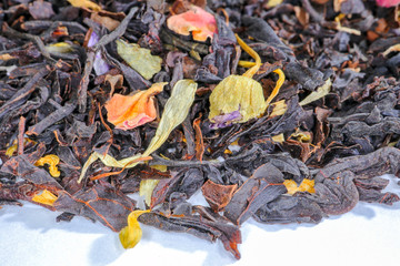 black tea with fruit pieces and flower petals macro isolate