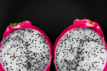 Dragon fruit. Vibrant Dragon Fruit on black background. Sliced white dragon fruit or pitaya on black plate on the table, close-up. Tropical and exotic fruits. Healthy and vitamin food concept.