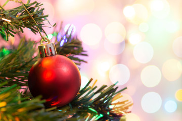 Christmas decoration. Hanging red balls on pine branches Christmas tree garland and ornaments over abstract bokeh background with copy space.