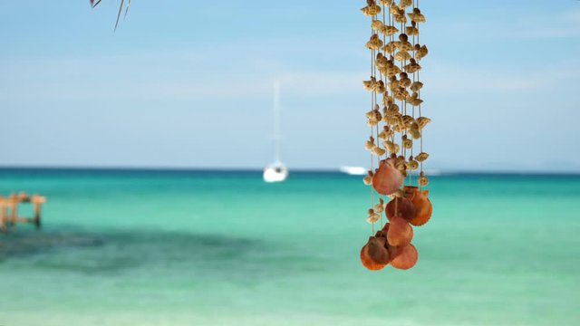 A seashell mobile sways with the wind, on a beautiful  beach of Thailand.A seashell mobile sways with the wind, on a beautiful  beach of Thailand.A seashell mobile sways with the wind, on a beautiful 