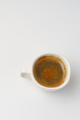 Cup with hot coffee on a white background. View from above
