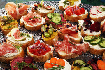 Assorted bruschetta with various toppings. Appetizing bruschetta or brie crostini. Variety of small sandwiches. Mix bruschetta on table