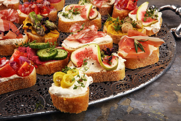 Assorted bruschetta with various toppings. Appetizing bruschetta or brie crostini. Variety of small sandwiches. Mix bruschetta on table