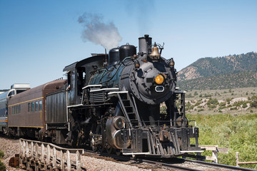Fototapeta na wymiar Vintage Steam Train Billowing Smoke as it Moves Through the Mountains.