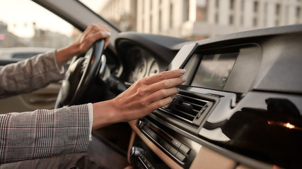 Staying connected. Cropped photo of female hand holding her smartphone while driving a car