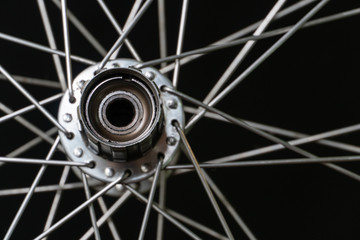  Bicycle repair. Cleaning and replacement of grease in the rear hub of the bike. The rear wheel of the bike on a black background. Spokes and hubs are gray. Modern workshop. Freehub close up