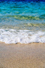 Detail of a wave of the sea on the shore of the sandy beach