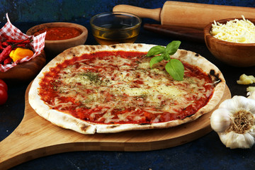 Pizza with tomatoes, mozzarella cheese, basil. Delicious italian pizza on wooden pizza board.