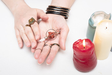 Fortune teller holding in hands a magic pendulum close up.