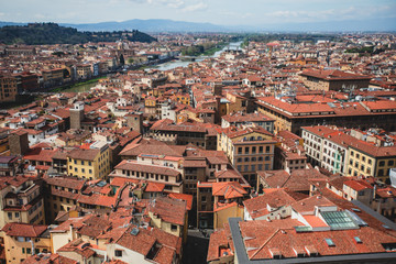 Fototapeta na wymiar Beautiful super wide-angle aerial view of Florence, Italy with Florence Cathedral di Santa Maria del Fiore, mountains, skyline and scenery beyond the city, seen from the tower of Palazzo Vecchio