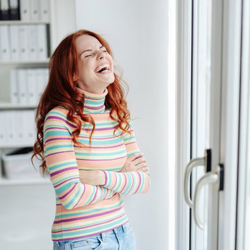Young redhead woman enjoying a good joke