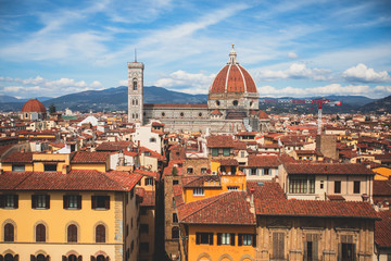 Fototapeta premium Beautiful super wide-angle aerial view of Florence, Italy with Florence Cathedral di Santa Maria del Fiore, mountains, skyline and scenery beyond the city, seen from the tower of Palazzo Vecchio
