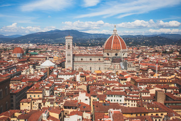 Fototapeta na wymiar Beautiful super wide-angle aerial view of Florence, Italy with Florence Cathedral di Santa Maria del Fiore, mountains, skyline and scenery beyond the city, seen from the tower of Palazzo Vecchio