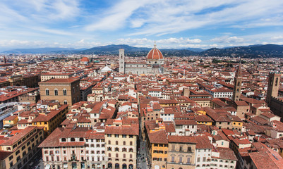 Obraz premium Beautiful super wide-angle aerial view of Florence, Italy with Florence Cathedral di Santa Maria del Fiore, mountains, skyline and scenery beyond the city, seen from the tower of Palazzo Vecchio