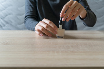 Woman doing the manicure. Removing the polish and putting on the cream. Woman that care his hands. Style concept.