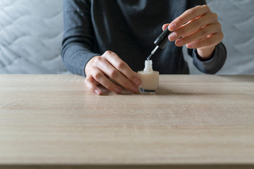 Woman doing the manicure. Removing the polish and putting on the cream. Woman that care his hands. Style concept.