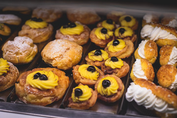 View of different traditional italian pastry candy desserts assorment, with cannoli, panna cotta, tartufo, amaretti, panettone, zeppole bomboloni, semifreddo, cartocci and others in Rome, Italy