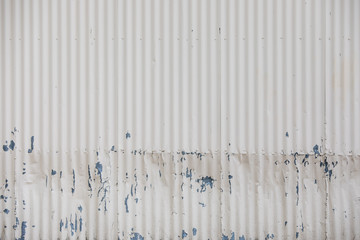 White corrugated wall with pealing paint makes nice textured background